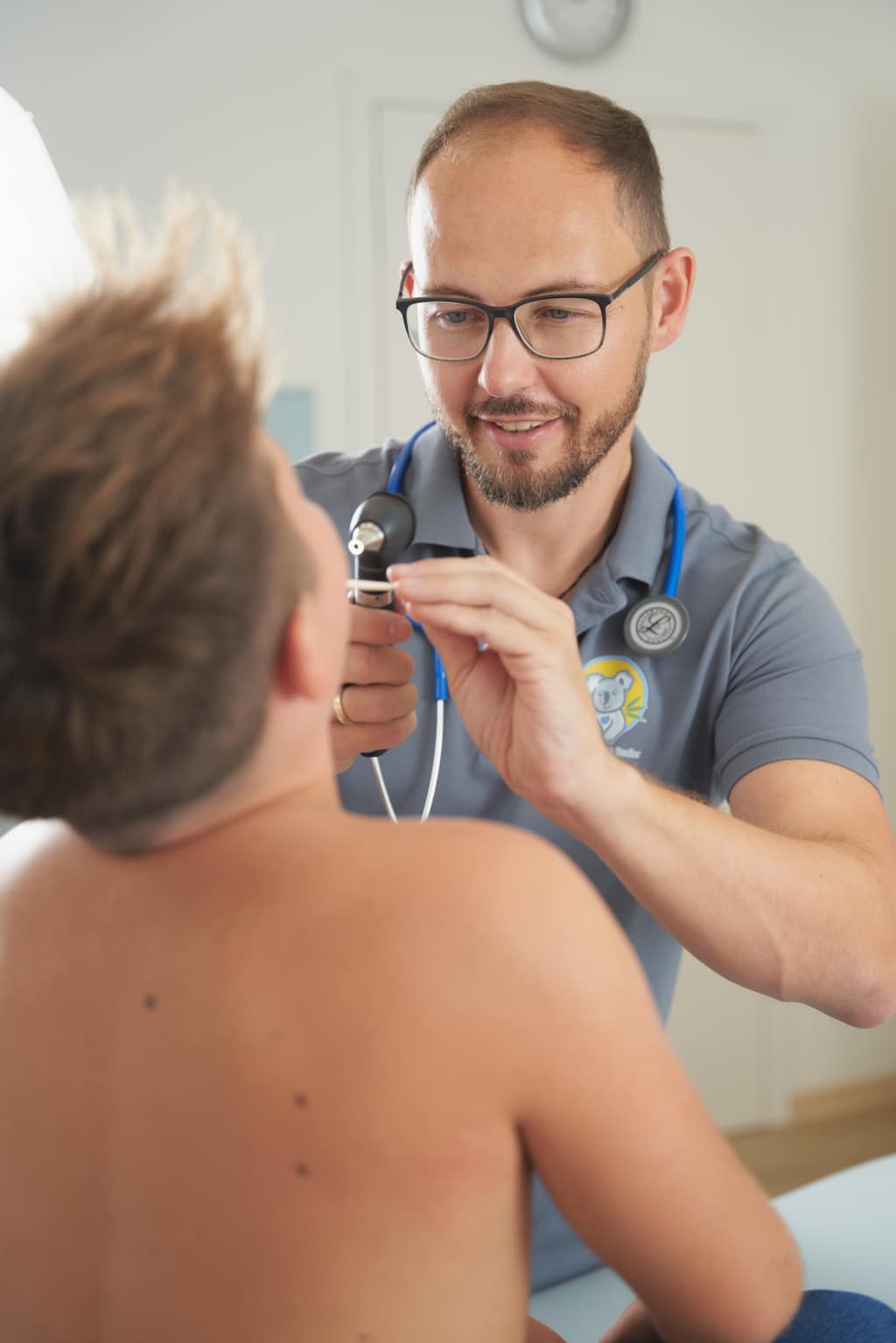 Dr. Christoph Rodler schaut in den Rachen eines Jungen