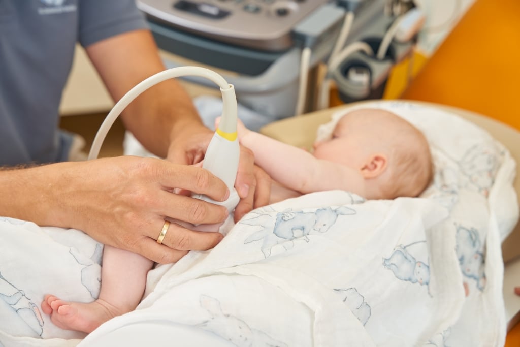 Dr. Christoph Rodler führt gerade eine Hüftsonographie bei einem Säugling durch