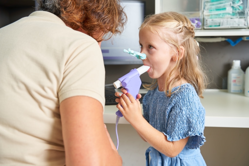 Ein kleines Mädchen bläst gerade eine Lungenfunktion